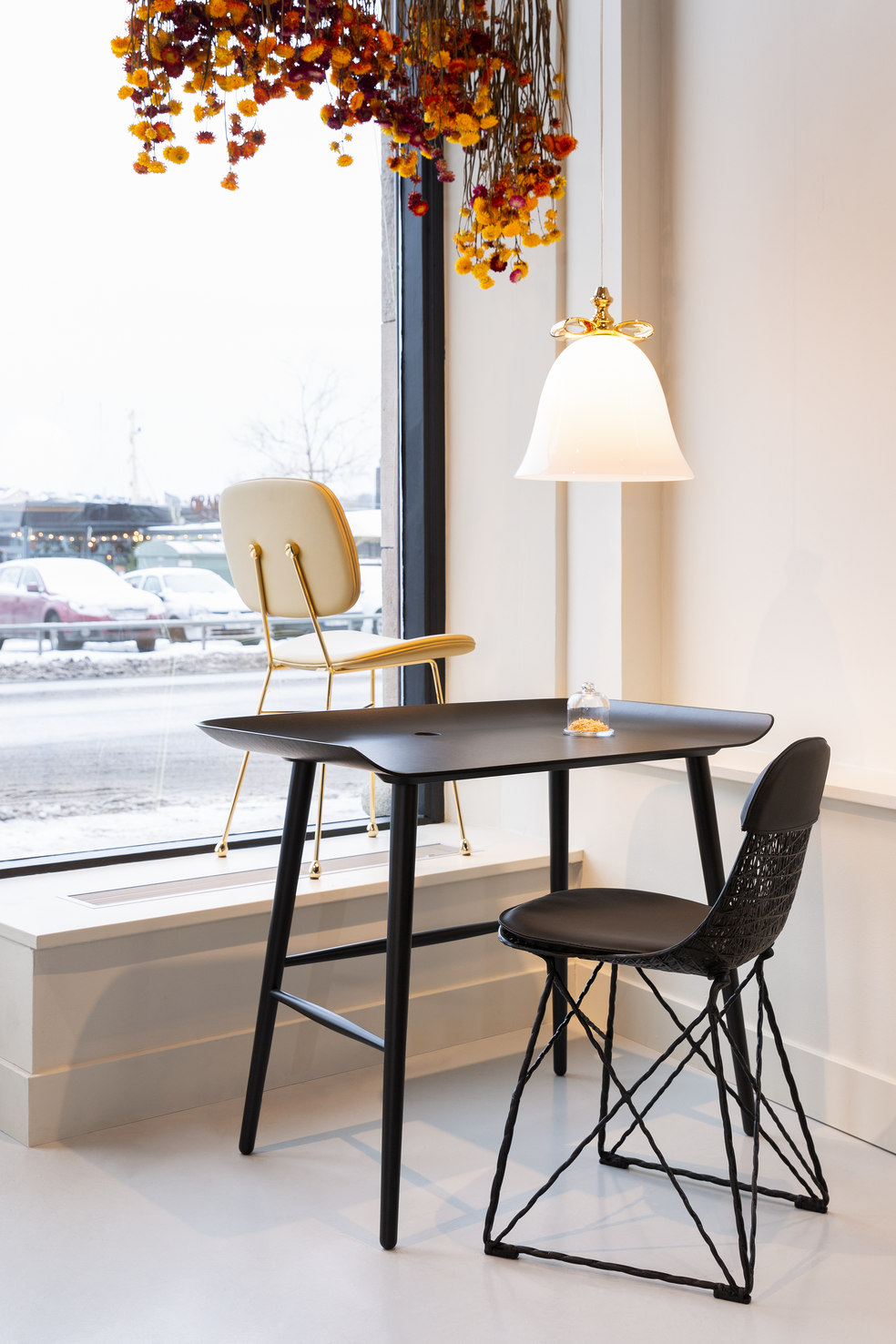 Bell lamp with a golden chair, a Carbon chair and aBlack woood table at our brand store in Stockholm 
